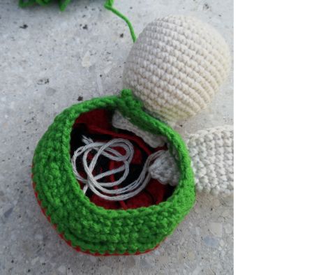 Underside view of the crochet watermelon turtle showing the tucked-in limbs